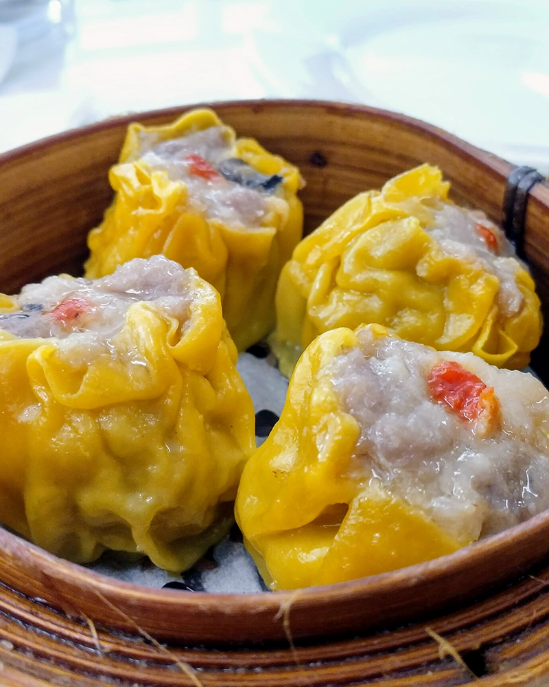 Yellow dim sum in steamer basket